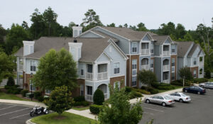 A garden apartment complex with several cars parked in the managed lot