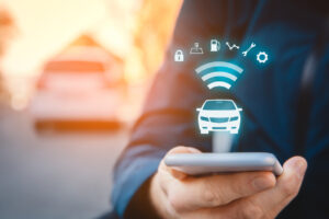 Person using a smart parking management system car app on their smartphone on street, car in background and wireless communication with the system 