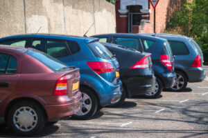 Cars parked in row on outdoor apartment parking with digital parking payments set up
